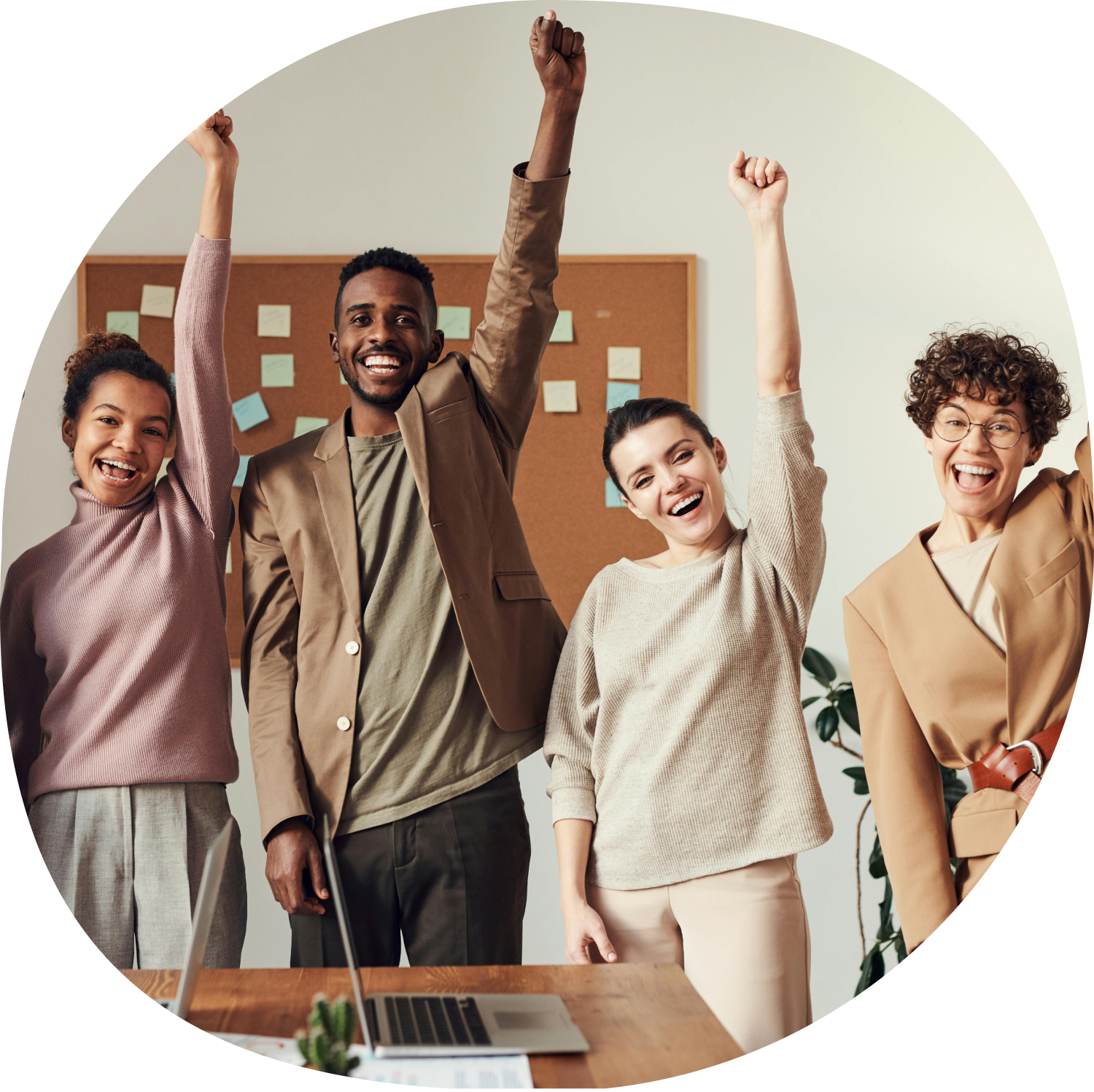 Group of diverse colleagues celebrating success with raised arms